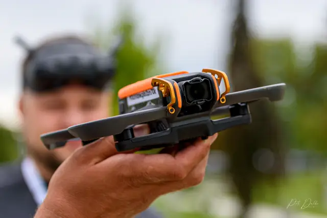 Pilot z goglami FPV i dronem w dłoni